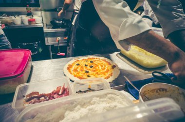 Şef mutfak at lezzetli pizza hazırlama beyaz üniformalı.