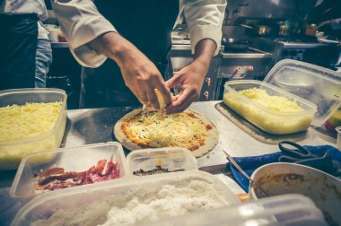 Şef mutfak at lezzetli pizza hazırlama beyaz üniformalı.