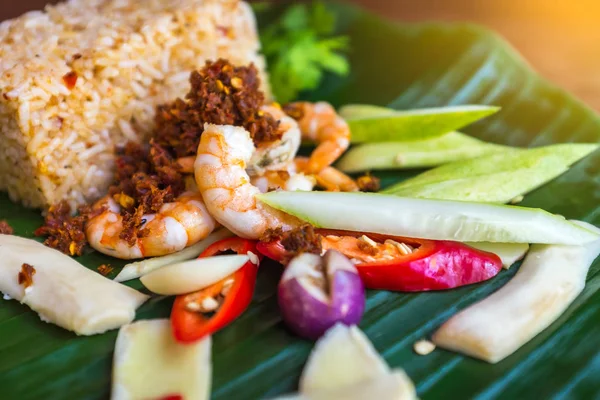 Fried rice with shrimp, chili dip and fines herbes served on banana leaf. — Stock Photo, Image