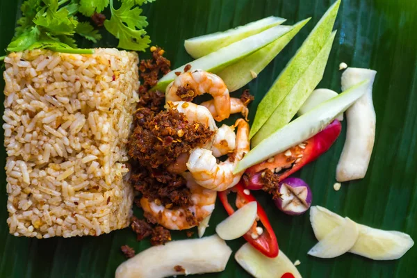 Top view of fried rice with shrimp, chili dip and fines herbes served on banana leaf. — Stock Photo, Image