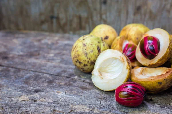 Küçük Hindistan cevizi myristica ahşap arka plan üzerinde kokulu tohum plasenta gibi kapaklı