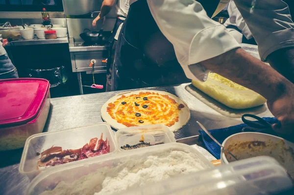 Şef mutfak at lezzetli pizza hazırlama beyaz üniformalı.