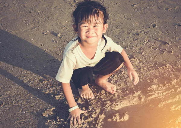 Feliz criança asiática tem diversão cavando na areia. Viajar de férias . — Fotografia de Stock