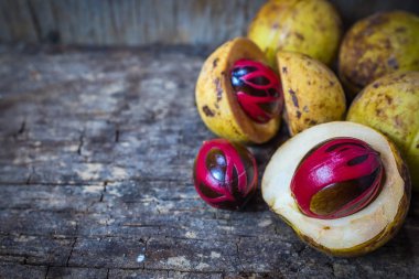 Küçük Hindistan cevizi myristica ahşap arka plan üzerinde kokulu tohum plasenta gibi kapaklı