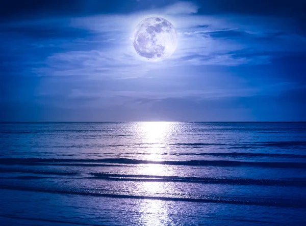 Kleurrijke hemel met donkere wolk en heldere volle maan over zeegezicht. — Stockfoto