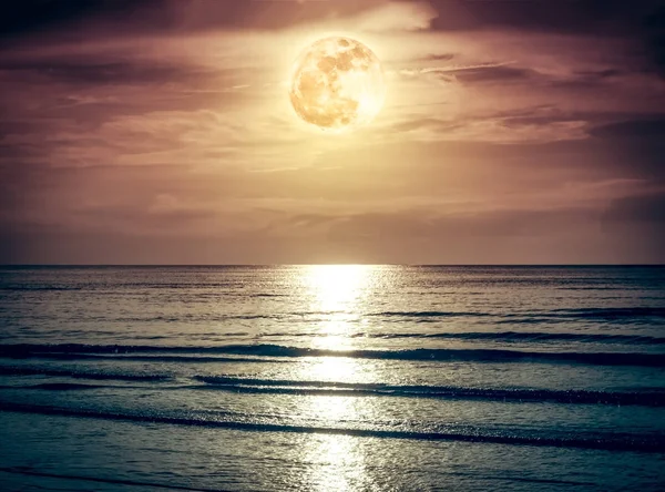 Kleurrijke hemel met donkere wolk en heldere volle maan over zeegezicht. — Stockfoto