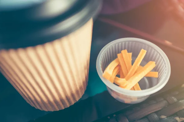 Kant-en klaarmaaltijden om papier warme koffie drinken cup en snack op houten tafel. — Stockfoto