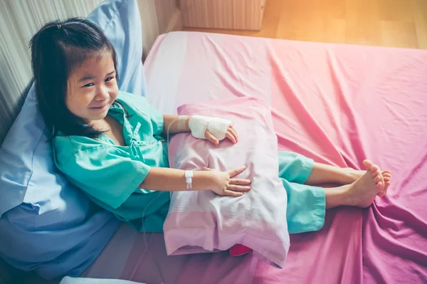 Choroby azjatycki dziecko przyjęte do szpitala z soli fizjologicznej dożylne (Iv) pod ręką. — Zdjęcie stockowe