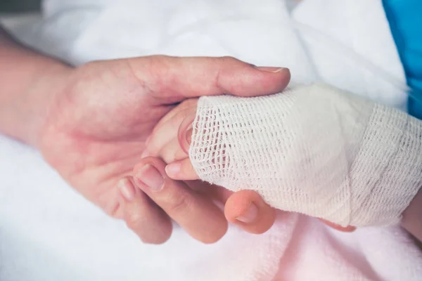 Mão fechada de pai segurando mão de criança no hospital . — Fotografia de Stock