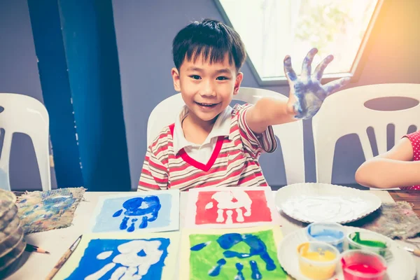Asian boy smiling and showing hands in paint. Pop art style. — Stock Photo, Image