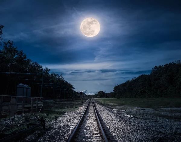 Cielo azul y luna llena sobre siluetas de árboles y ferrocarriles . — Foto de Stock