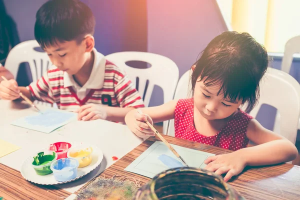 Feliz chica asiática pintando color rojo en obras de arte con pincel . — Foto de Stock