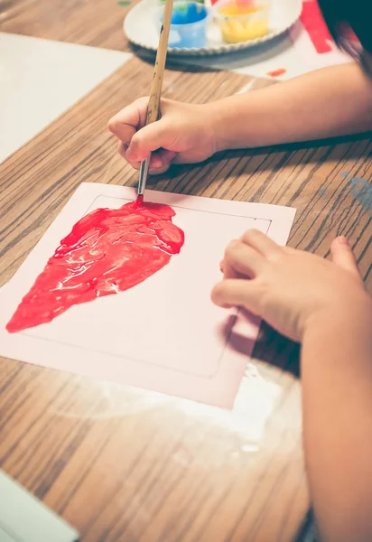 Felice ragazza asiatica pittura di colore rosso su opere d'arte con pennello . — Foto Stock