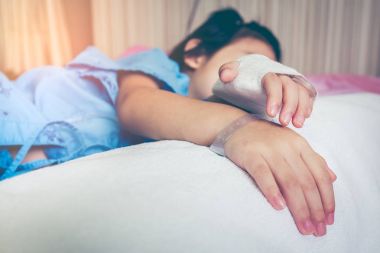 Yandan hastalık Asyalı çocuk tuzlu intravenöz (IV) damla ile hastaneye kabul. 