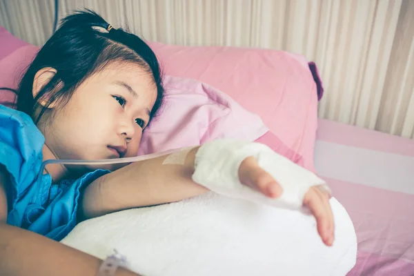 一方生理食塩水の点滴 (Iv) と病院に認められる病気アジア子供. — ストック写真