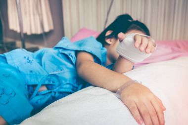 Yandan hastalık Asyalı çocuk tuzlu intravenöz (IV) damla ile hastaneye kabul.