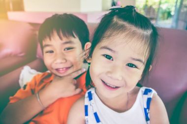 Kız ve erkek gülümseyen ve v-sign gösterilen kardeşim. Vintage sesi.