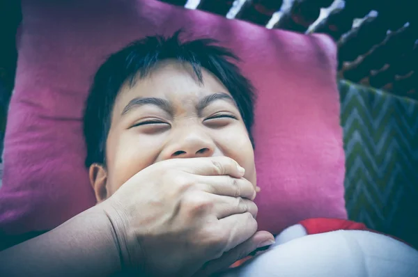 Asian child being attacked by someone that covers child's mouth. — Stock Photo, Image