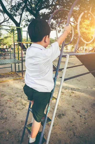 Asijský kluk baví na dětské hřiště. Outdoorové aktivity — Stock fotografie