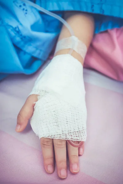 Zamknąć z soli fizjologicznej dożylnej kroplówki (iv) w rękę pacjenta dziecka. — Zdjęcie stockowe