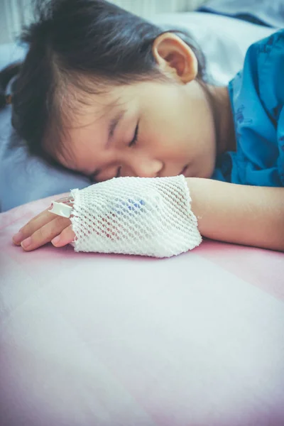 Doença asiática criança admitida no hospital com solução salina intravenosa (IV) na mão . — Fotografia de Stock