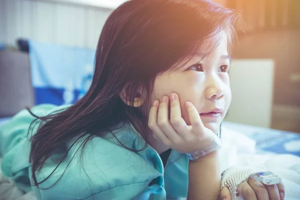 Illness asian child admitted in hospital with saline iv drip on hand. — Stock Photo, Image