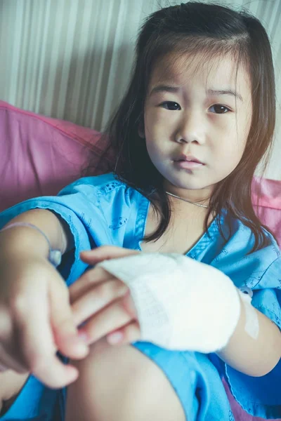 Enfermedad asiática niño ingresado en el hospital con solución salina goteo iv en la mano . —  Fotos de Stock