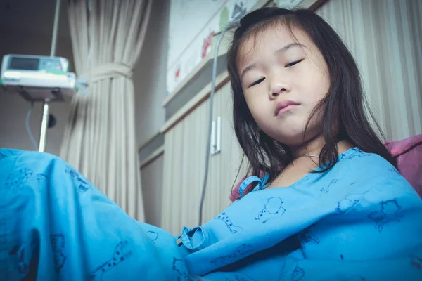 Illness asian child admitted in hospital with saline iv drip on hand. — Stock Photo, Image