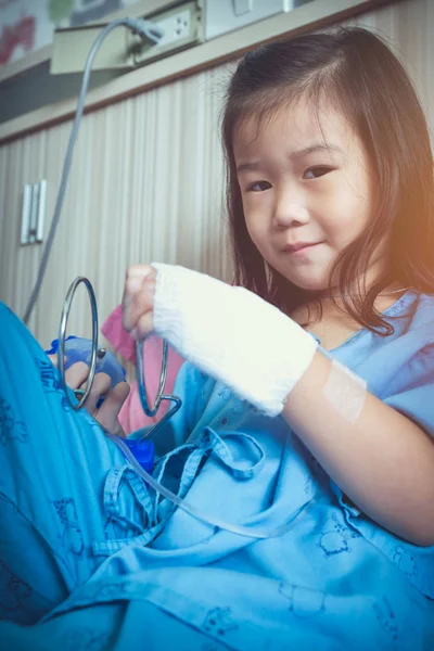 Illness asian child admitted in hospital with IV drip on hand. — Stock Photo, Image