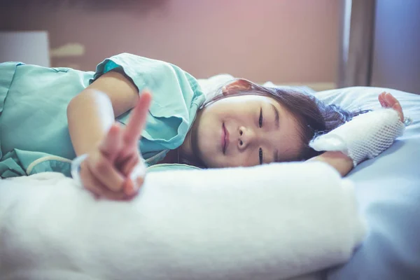 Illness asian child admitted in hospital with saline iv drip on hand. — Stock Photo, Image