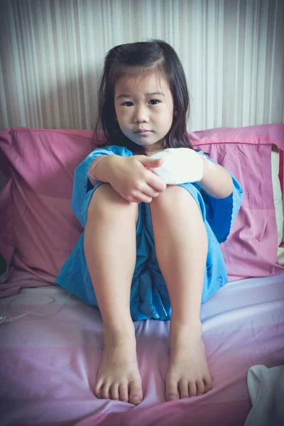 Illness asian child admitted in hospital with saline iv drip on hand. — Stock Photo, Image