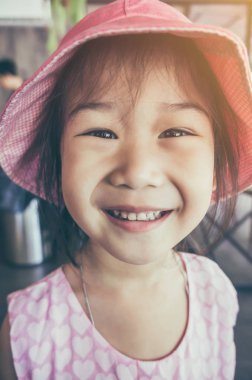 Gülümseyen ve kameraya bakarak çocuk. Vintage film etkisi.