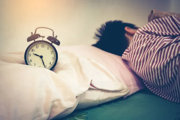 Азіатський хлопчик спить на ліжко., антикварні чорний будильник поблизу шляхом. Дія фільтр старовинні фільму. — стокове фото
