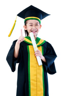 Asyalı çocuk gülümseyen ve kap tutan mezuniyet elbise. 