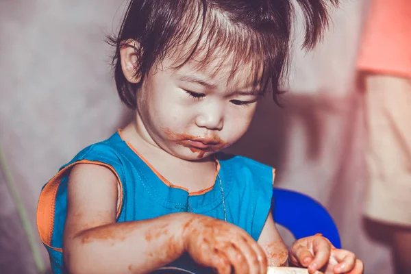 汚れた顔で食べる子。自分で行う概念。ビンテージ トーン. — ストック写真