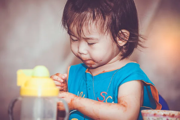 Kind isst mit fleckigem Gesicht. Do it yourself Konzept. Vintage-Ton. — Stockfoto