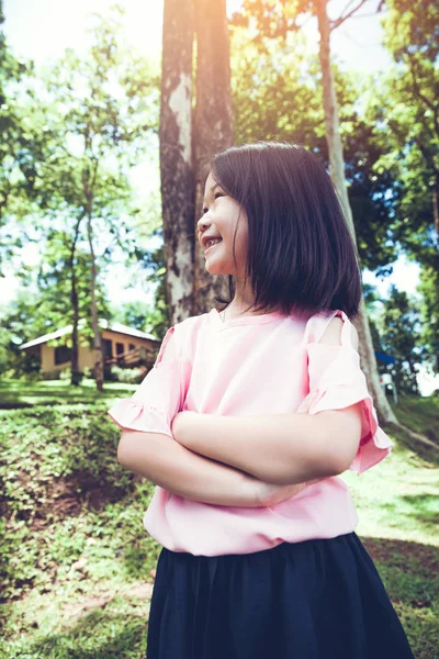 Портрет улыбающейся маленькой азиатской девочки в парке . — стоковое фото