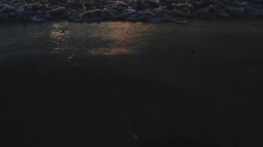 Kum, deniz manzarası ve sabahları gün doğumu. Kamera hareketini aşağıdan yukarıya doğru yatır. 4k Uhd