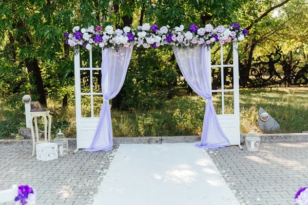 wedding decor at a visiting ceremony, a wedding arch of white color with violet flowers
