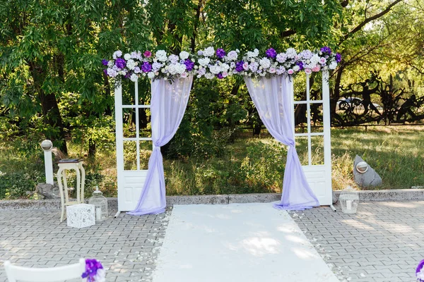 wedding decor at a visiting ceremony, a wedding arch of white color with violet flowers