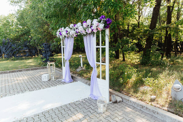 wedding decor at a visiting ceremony, a wedding arch of white color with violet flowers