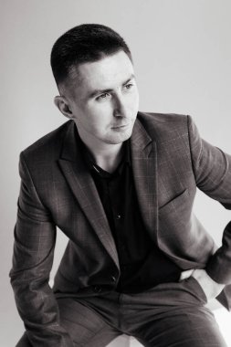 Ofis masasında oturan ve dizüstü bilgisayarda çalışan işadamı, takım elbiseli genç bir adamın portresi.