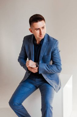 Ofis masasında oturan ve dizüstü bilgisayarda çalışan işadamı, takım elbiseli genç bir adamın portresi.