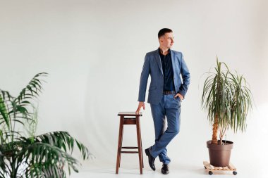 Ofis masasında oturan ve dizüstü bilgisayarda çalışan işadamı, takım elbiseli genç bir adamın portresi.