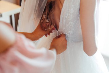 Gelinin düğün sabahı, gelinin lüks toplantılarında, bir elbise bağlarlar ve ayakkabı giyerler.