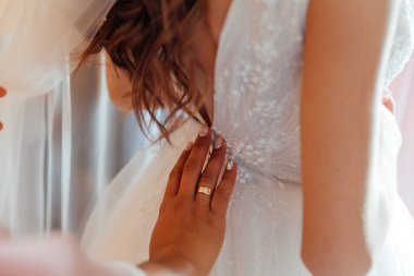 Gelinin düğün sabahı, gelinin lüks toplantılarında, bir elbise bağlarlar ve ayakkabı giyerler.