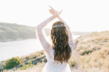 Şatafatlı beyaz gelinlikli gelin gün batımında doğada