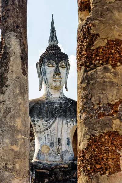 Buddha statue among the ruins