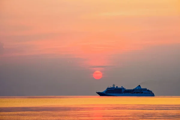 Reizen per cruiseschip in de oceaan bij zonsondergang Stockfoto