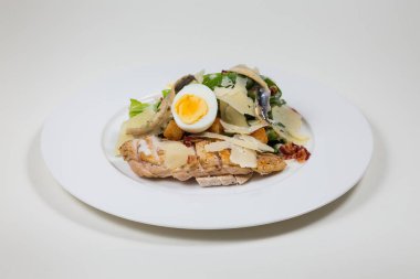 Yumurta ve peynir beyaz bir arka plan üzerinde beyaz bir tabakta Tavuk salatası